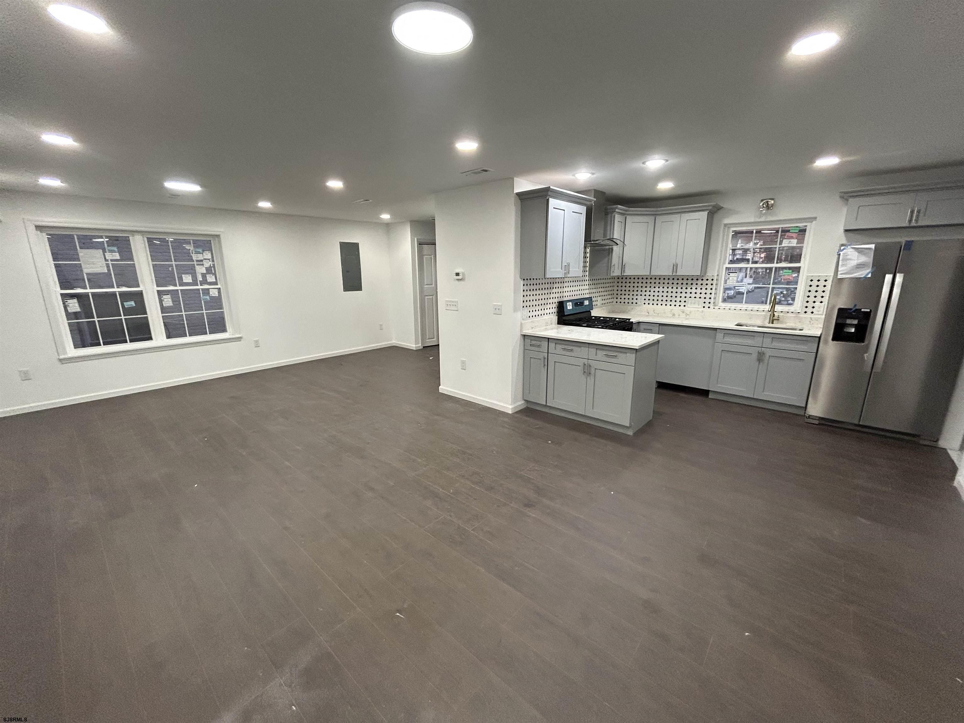 2821 Arctic Avenue, Unit 1 Atlantic City, NJ 08401 - Photo 3 of 10 a large kitchen with stainless steel appliances granite countertop a large counter top a stove and a refrigerator