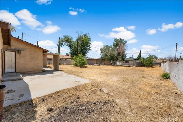 a view of a house with a yard and potted plants