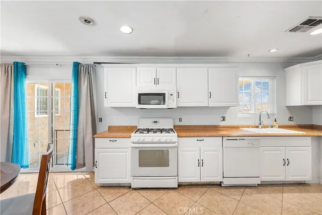 a kitchen with granite countertop white cabinets and white appliances