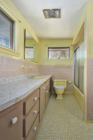 a bathroom with a granite countertop sink a toilet and a mirror
