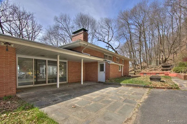 a view of a house with a yard and large tree