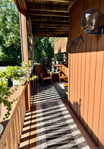 a view of a patio with table and chairs potted plants with wooden floor and fence