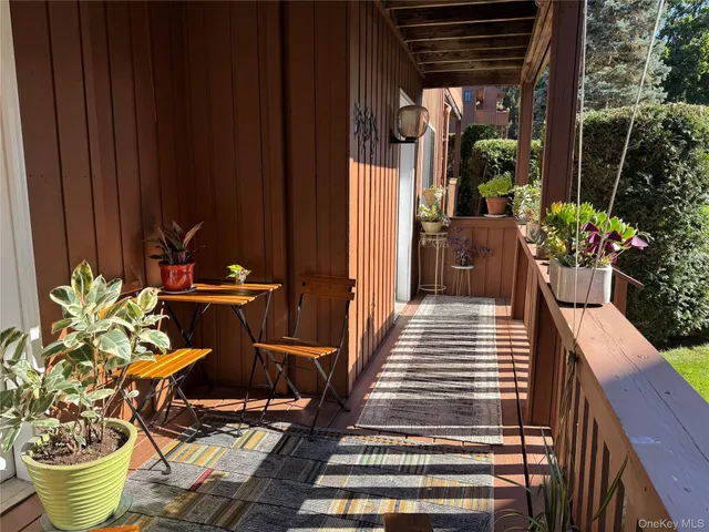 a view of a balcony with chairs and a potted plant