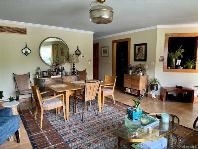 a dining room with wooden floor a glass table and chairs