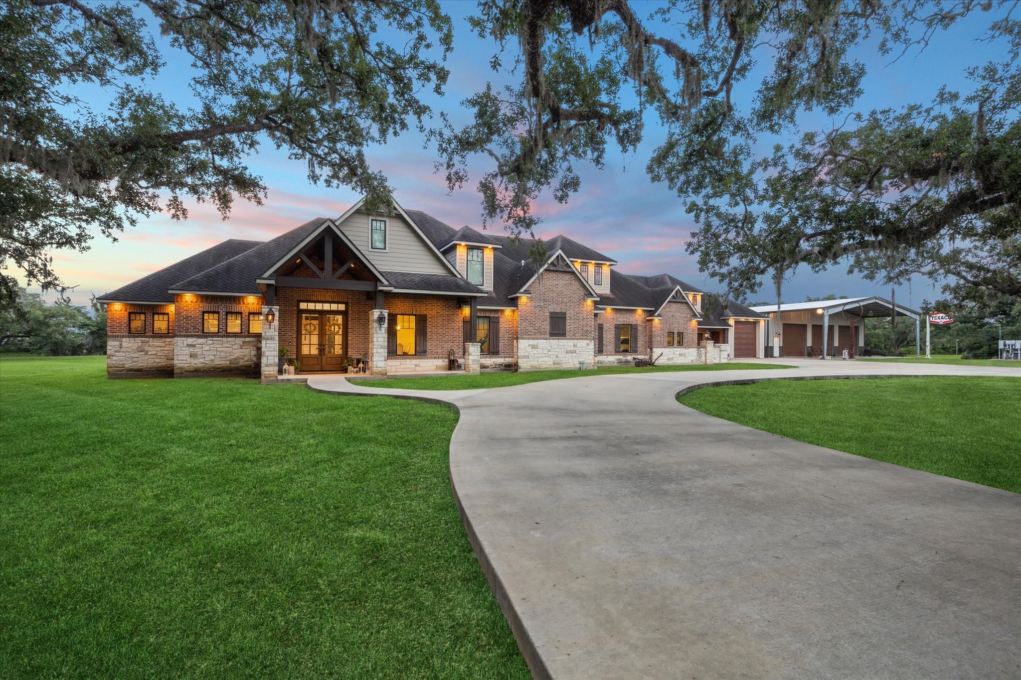 Welcome to this custom-built, multi-generational residence, perfectly situated on 5.13 acres of serene, picturesque land. As you approach, 9 gas lighting fixtures warmly illuminate the entrances to the home, casting a welcoming glow beneath the shade of century-old oak trees, adding timeless charm and elegance to this peaceful retreat.