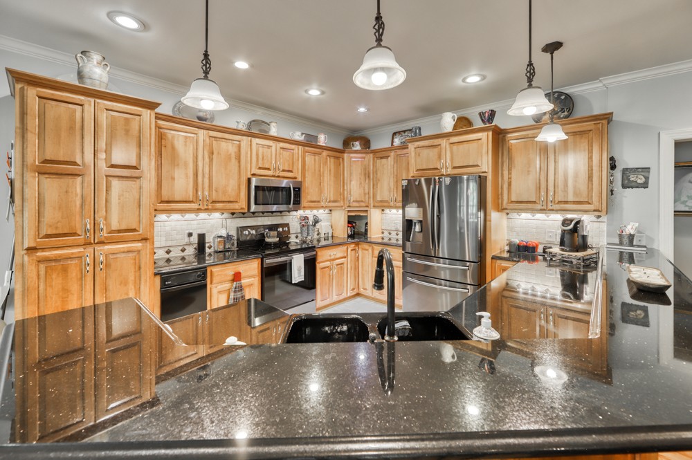 7880 Pinewood Road Fairview, TN 37062 - Photo 17 of 46 a kitchen with stainless steel appliances granite countertop a refrigerator a oven a sink a stove and white cabinets with wooden floor