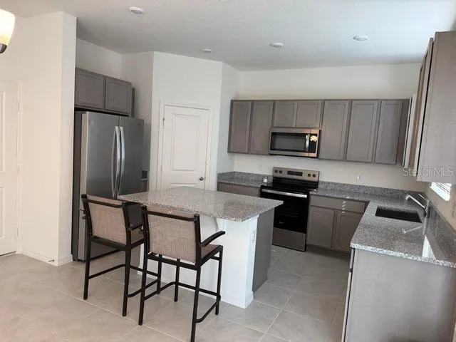 a kitchen with a refrigerator and a stove top oven