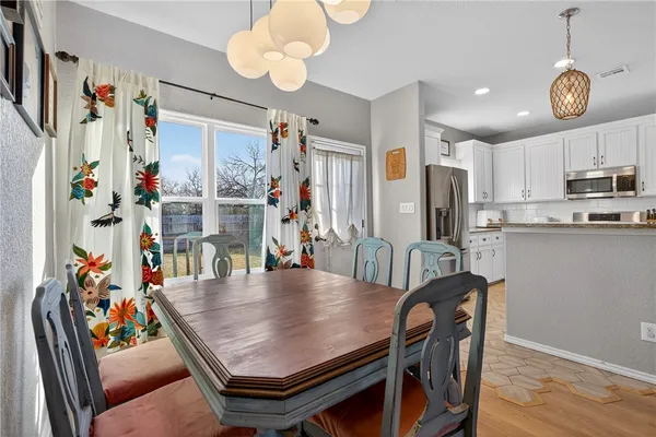 a view of kitchen with stainless steel appliances furniture refrigerator dining table and chairs
