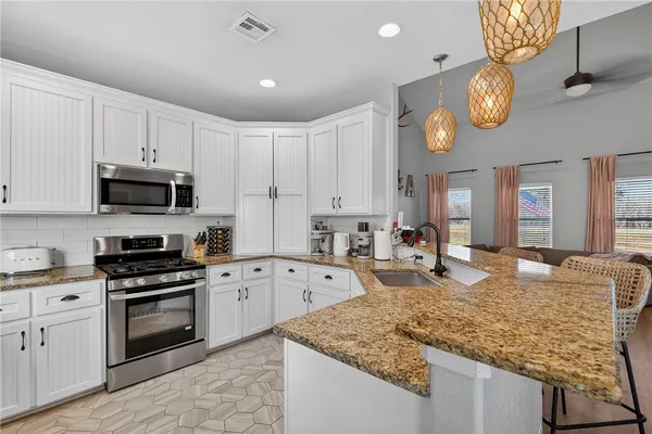 a kitchen with stove top oven and cabinets