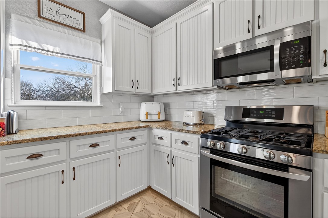 20401 County Road 1740 Mathis, TX 78368 - Photo 23 of 35 a kitchen with stainless steel appliances white cabinets and a stove a sink