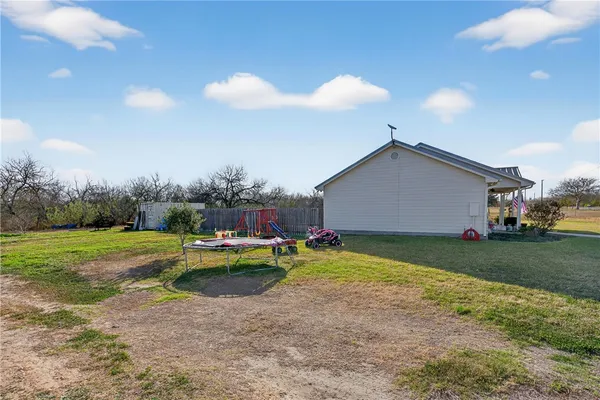 a view of a house with backyard and sitting area