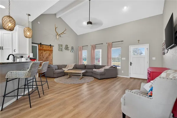 a living room with furniture kitchen view and a flat screen tv