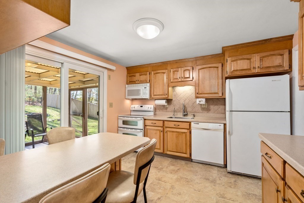 32 Eaton Road Framingham, MA 01701 - Photo 5 of 30 a kitchen with granite countertop a refrigerator stove top oven with a sink and dishwasher
