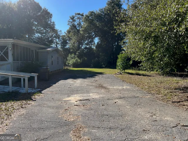 a backyard of a house with trees and wooden fence