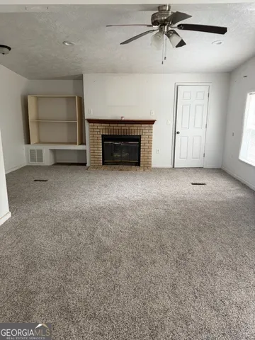 an empty room with a fireplace and windows
