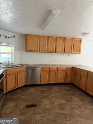 a kitchen with stainless steel appliances a cabinets a sink and a counter top space