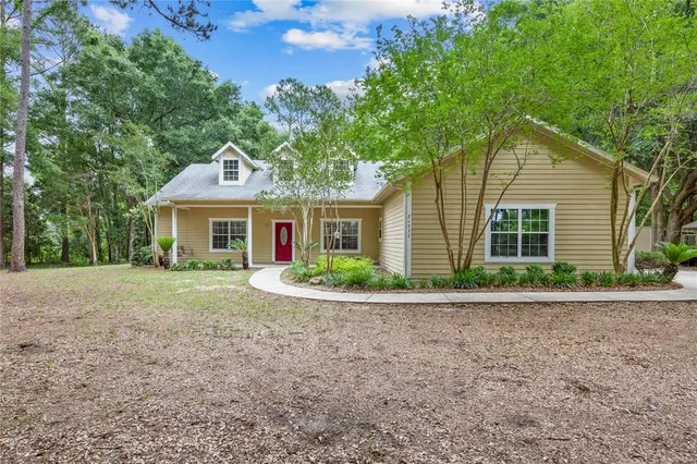 a front view of a house with a yard and potted plants