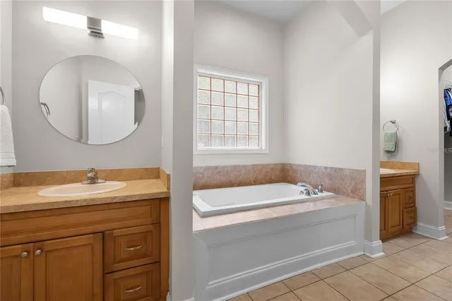 a bathroom with a tub a sink and a mirror