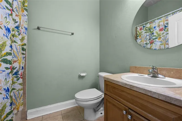 a bathroom with a sink a toilet and a shower curtain