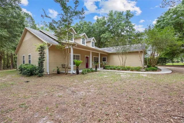 a view of a house with backyard and tree