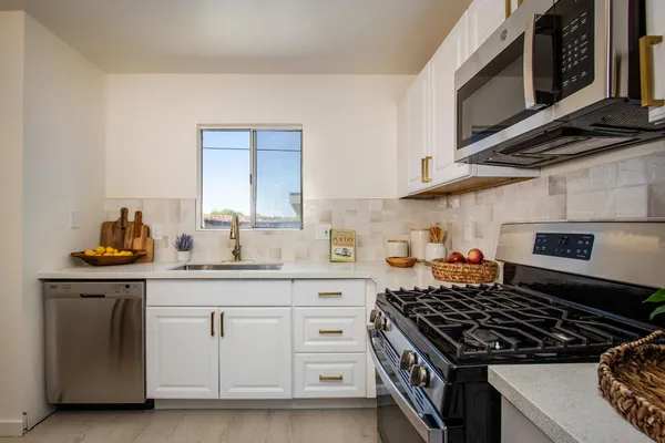a kitchen with white cabinets and appliances