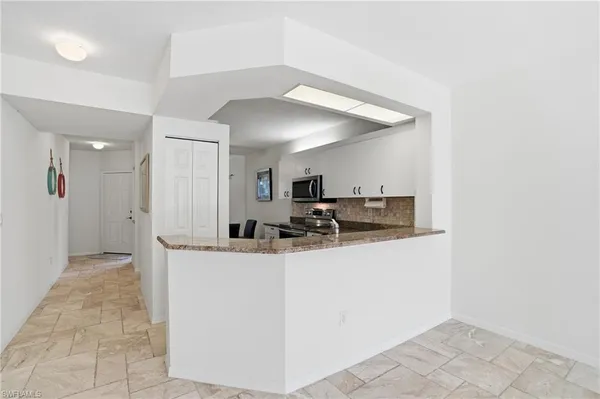 a view of a kitchen with kitchen island a sink wooden floor and a refrigerator