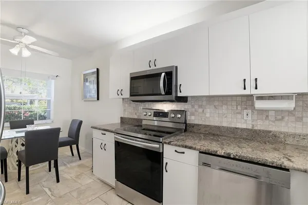 a kitchen with stainless steel appliances granite countertop a stove a sink and a microwave