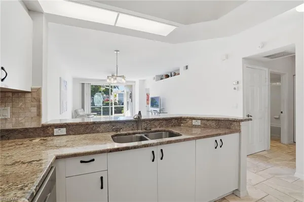 a kitchen with granite countertop a sink and a window