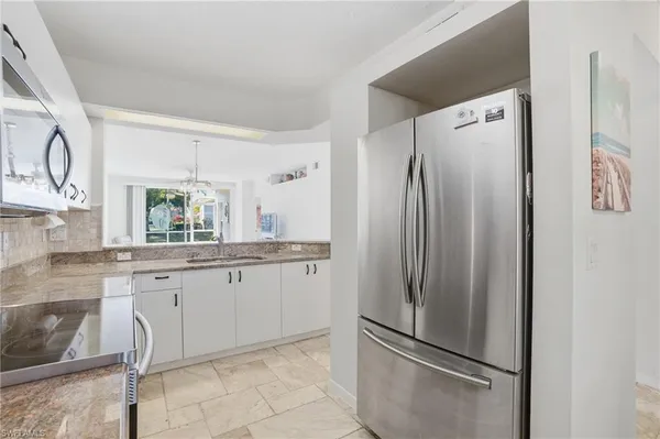 a kitchen with stainless steel appliances granite countertop a refrigerator and a sink