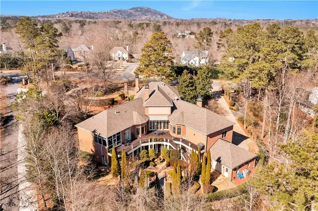an aerial view of a house with yard and trees