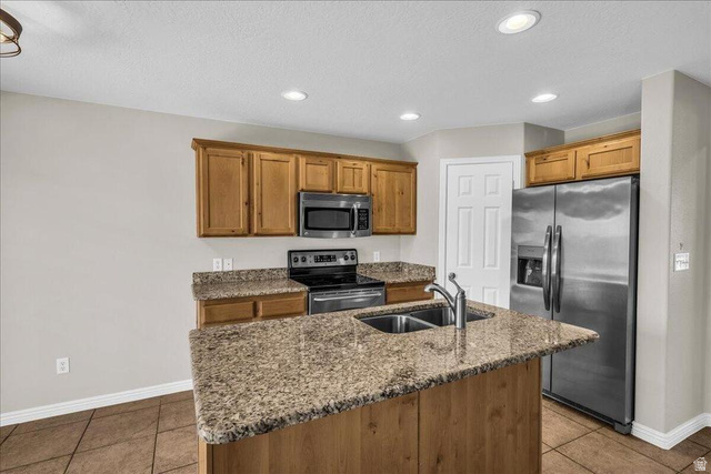 3155 South Hidden Dr Street, Unit 248 St. George, UT 84790 - Photo 5 of 24 Kitchen featuring a central island with a double basin sink, granite-style countertops, wood cabinetry, stainless steel appliances, and recessed lighting