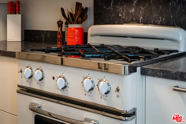 a kitchen with granite countertop a sink a stove and a refrigerator