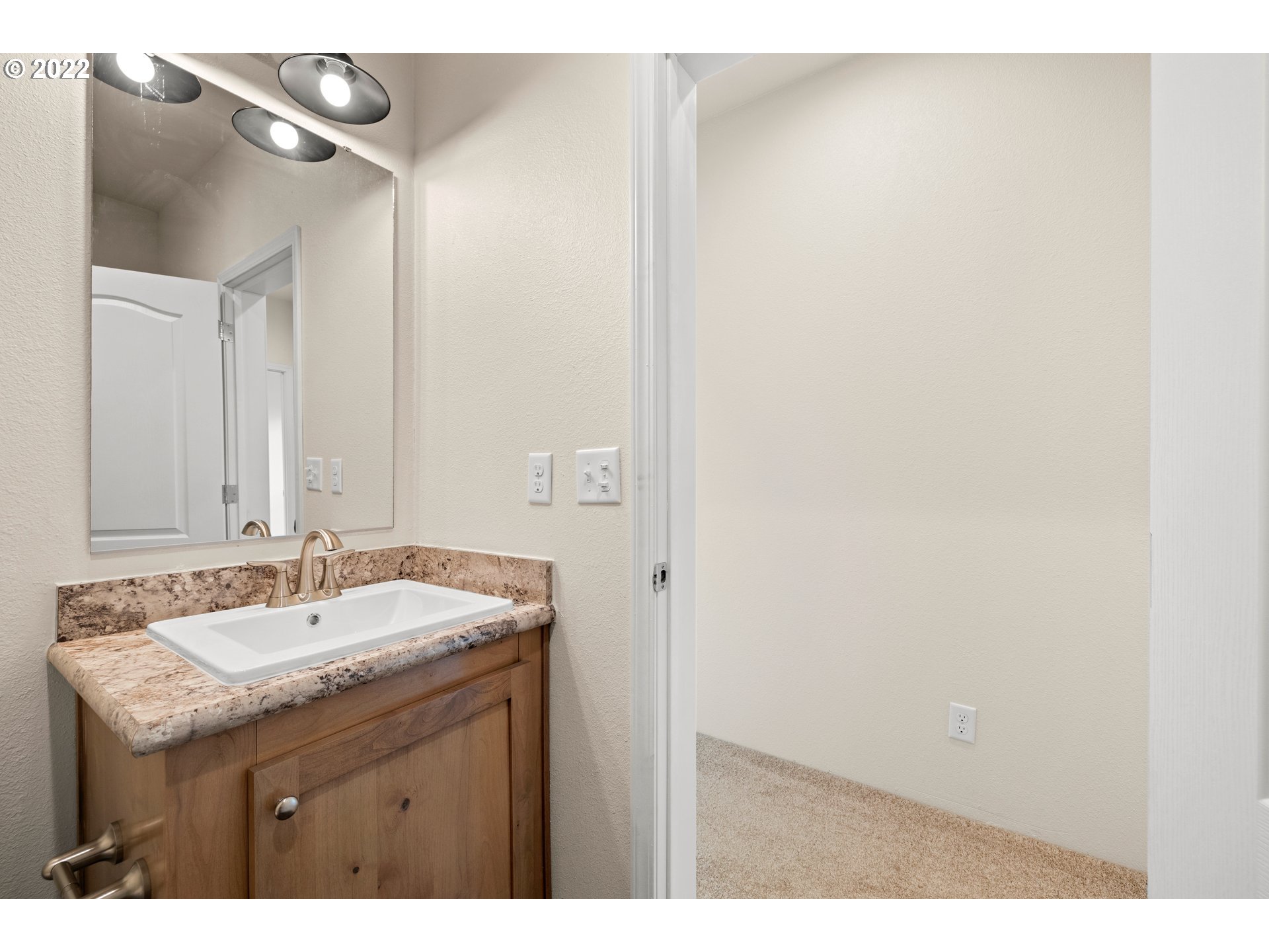 9700 Southwest Tualatin Road, Unit 12 Tualatin, OR 97062 - Photo 4 of 30 a bathroom with a granite countertop sink and a mirror
