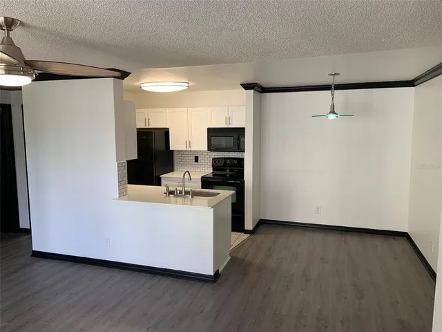 a view of kitchen with stainless steel appliances a refrigerator and a stove top oven