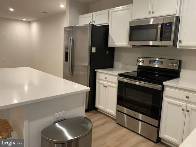 a kitchen with stainless steel appliances a stove microwave and refrigerator