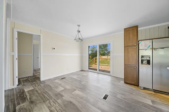 a view of empty room with wooden floor and cabinet