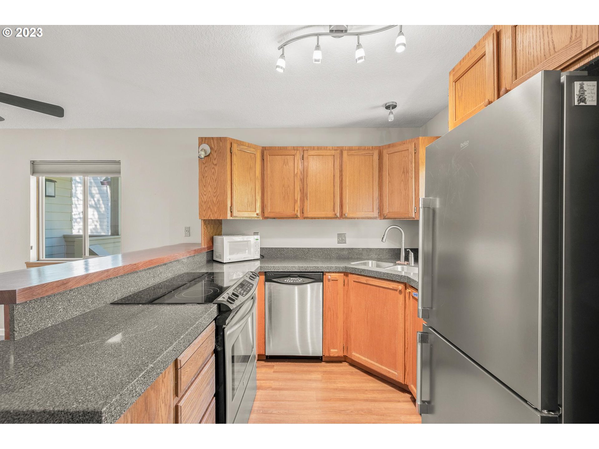 2785 Northwest Upshur Street, Unit B Portland, OR 97210 - Photo 12 of 35 a kitchen with stainless steel appliances granite countertop a refrigerator a sink and a stove