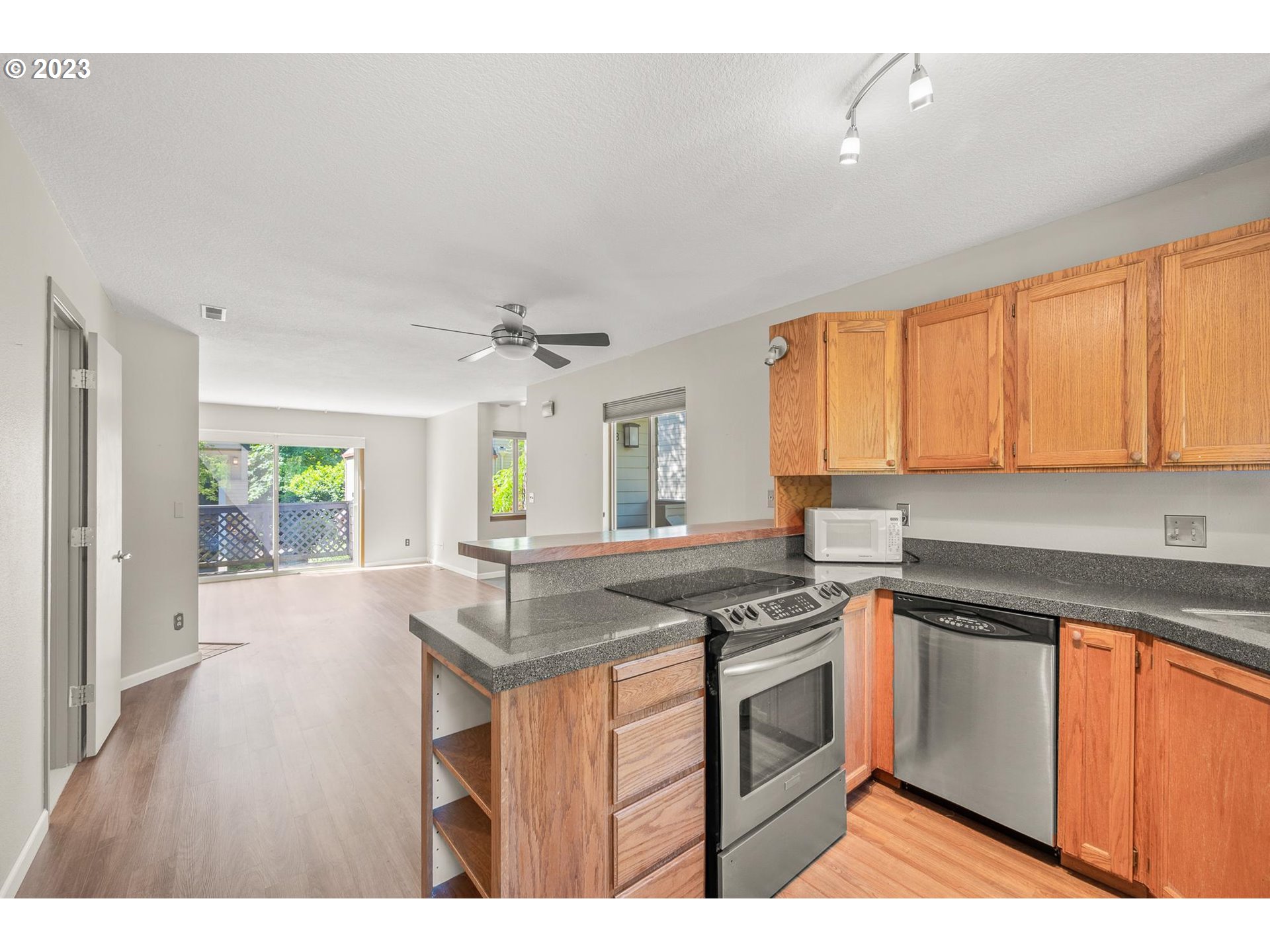 2785 Northwest Upshur Street, Unit B Portland, OR 97210 - Photo 13 of 35 a kitchen with granite countertop a stove a sink dishwasher and white cabinets with wooden floor