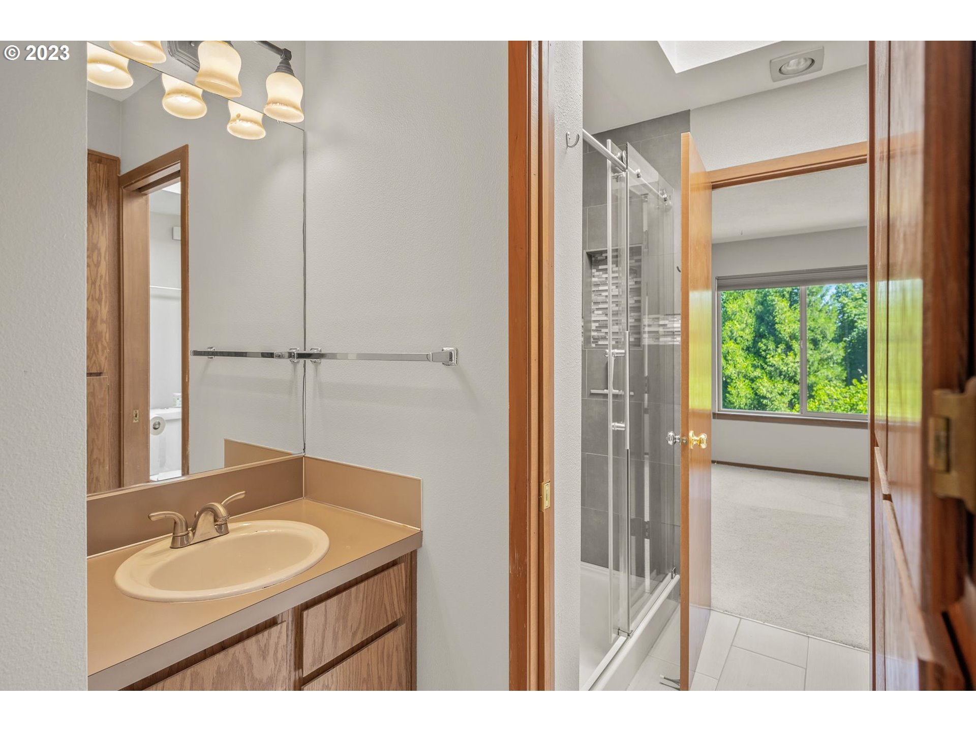 2785 Northwest Upshur Street, Unit B Portland, OR 97210 - Photo 23 of 35 a bathroom with a granite countertop sink a mirror and a shower