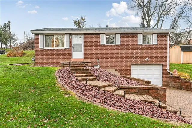 a front view of a house with a garden