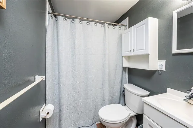 a white toilet sitting next to a bathroom sink