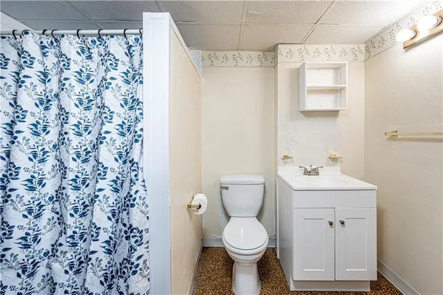 a bathroom with a sink a toilet and shower curtain