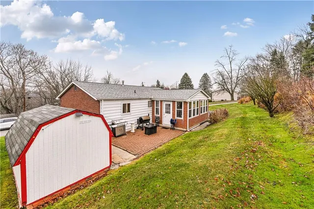 a view of a house with backyard and sitting area