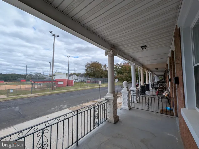a view of a porch with chairs and floor to ceiling window