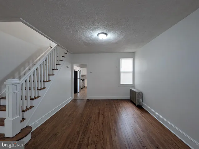 a view of room with stairs and wooden floor