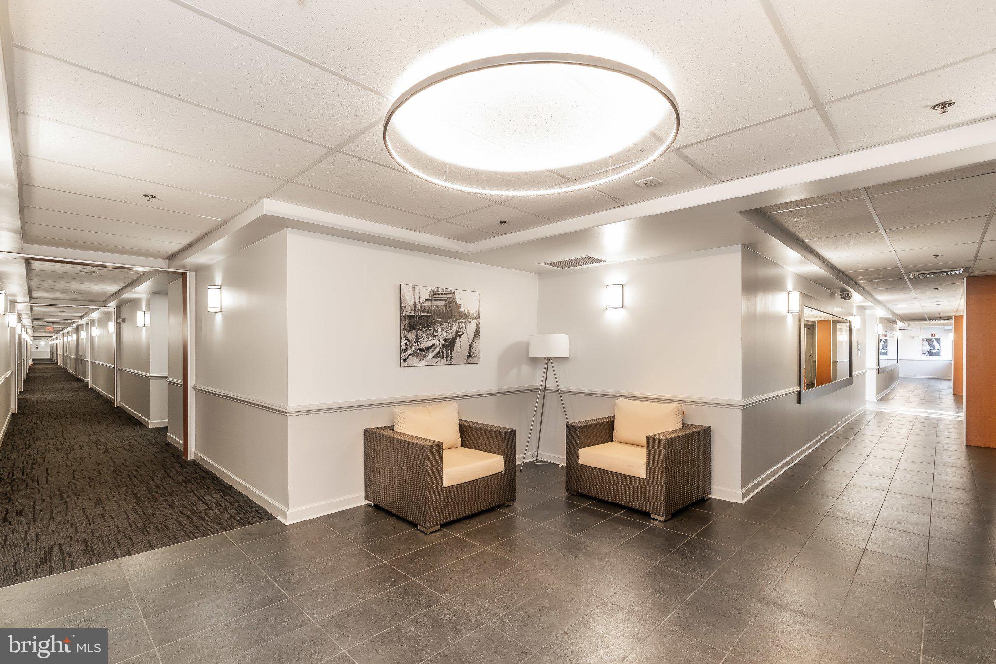 2702 Lighthouse Point East, Unit 532 Baltimore, MD 21224 - Photo 4 of 41 Modern corridor with inviting seating.