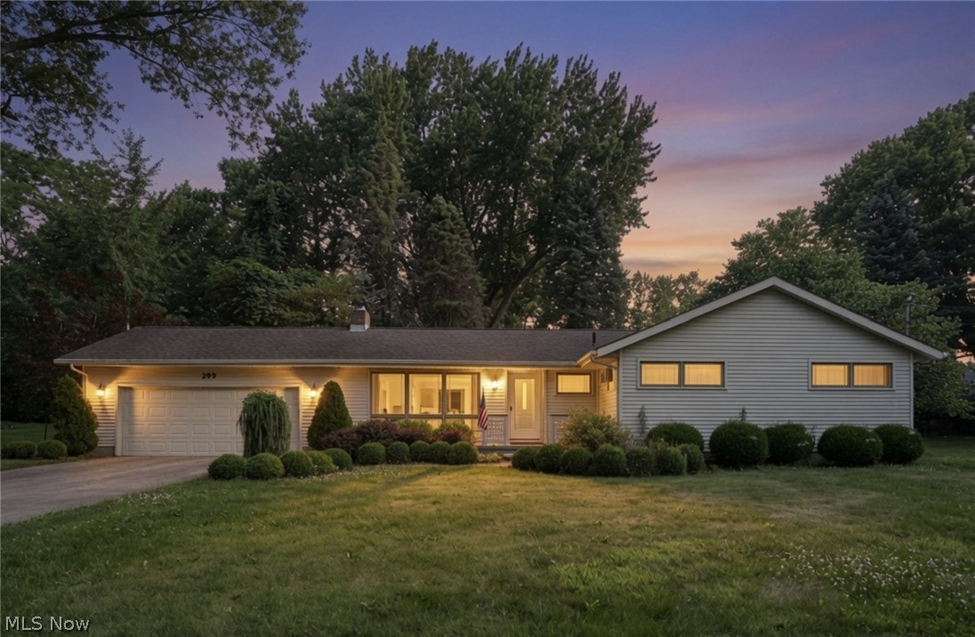 299 West Caston Road New Franklin, OH 44319 - Photo 2 of 23 Ranch-style residence featuring a prominent front lawn, mature perimeter trees, and a two-car garage