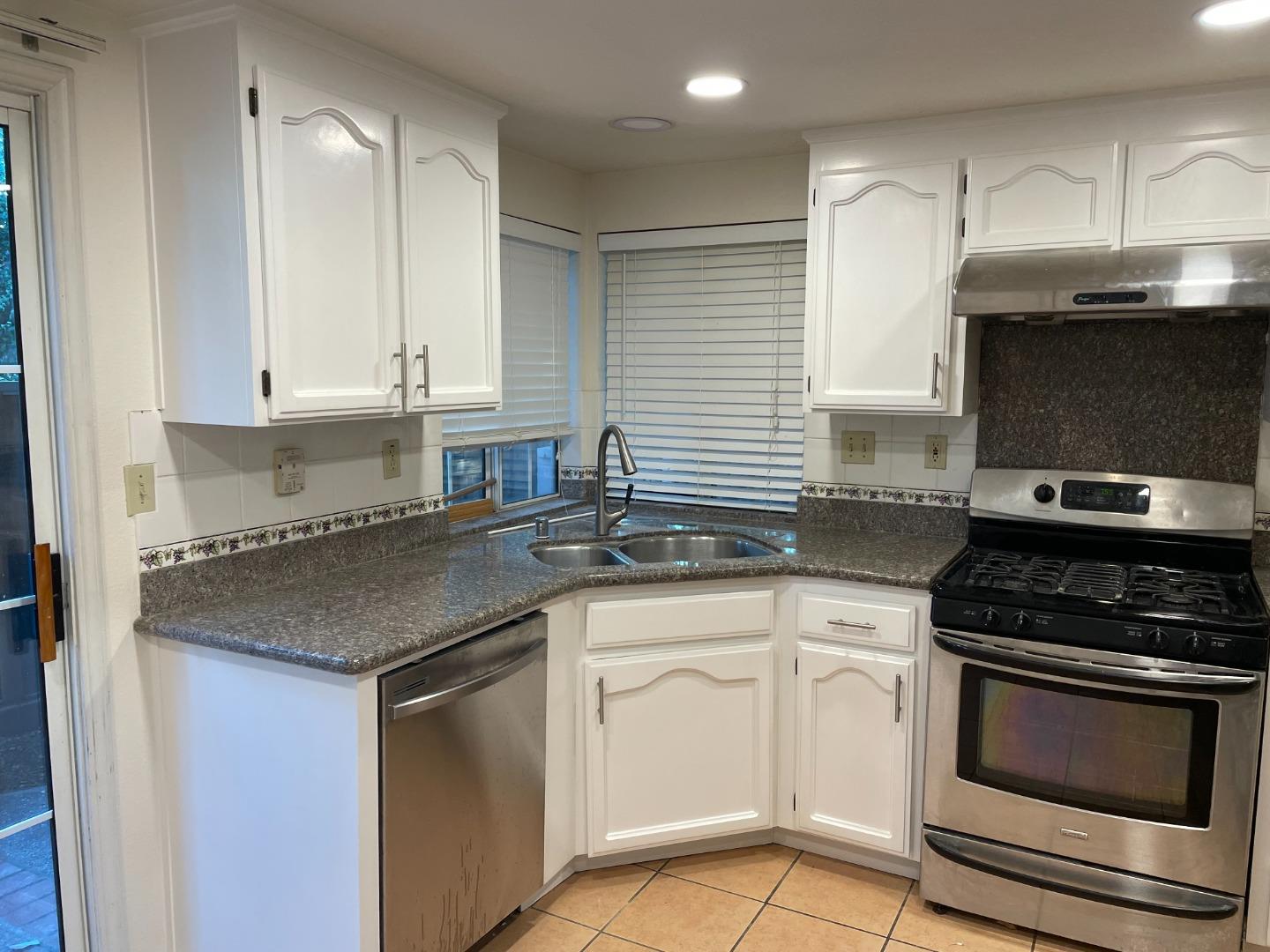 2294 Pinard Street Milpitas, CA 95035 - Photo 8 of 21 a kitchen with granite countertop a sink stainless steel appliances and white cabinets