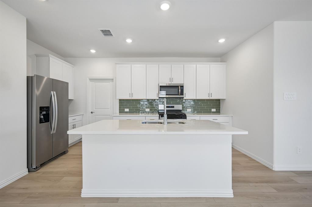 1705 Arches Road Anna, TX 75409 - Photo 16 of 33 a view of a kitchen with stainless steel appliances granite countertop a refrigerator a stove a sink and a microwave