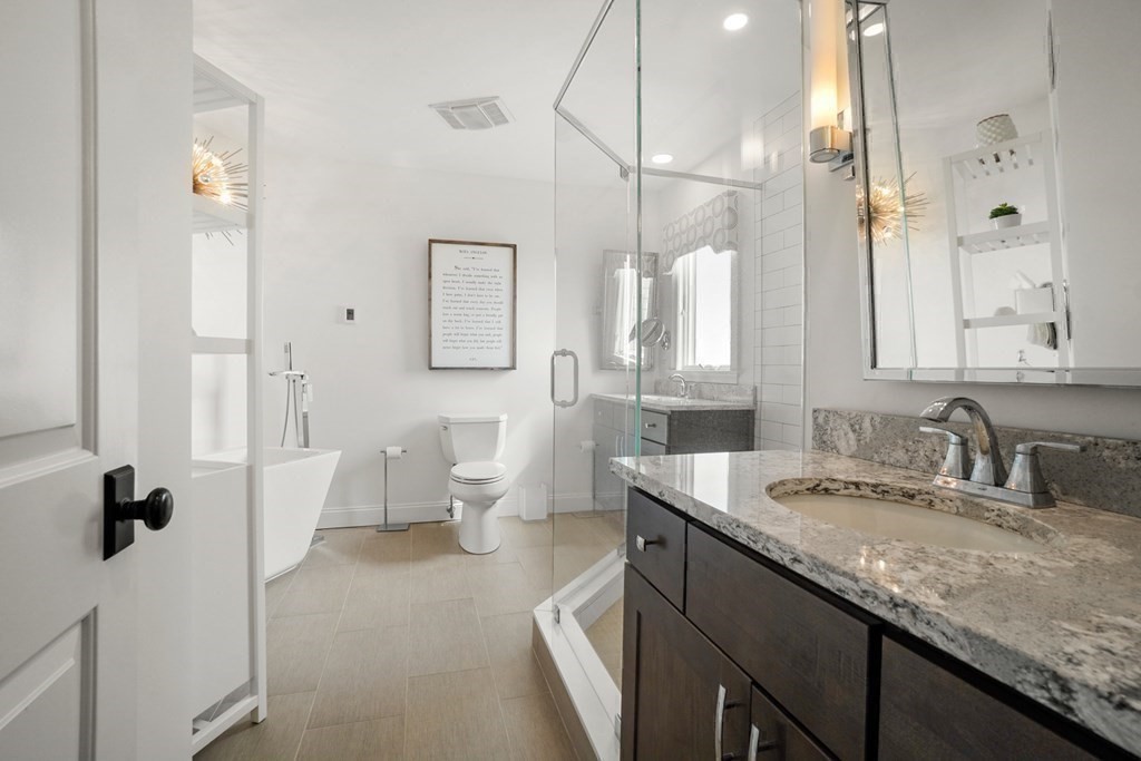 123 Gurnet Road Duxbury, MA 02332 - Photo 23 of 42 a bathroom with a granite countertop sink a toilet a mirror and shower